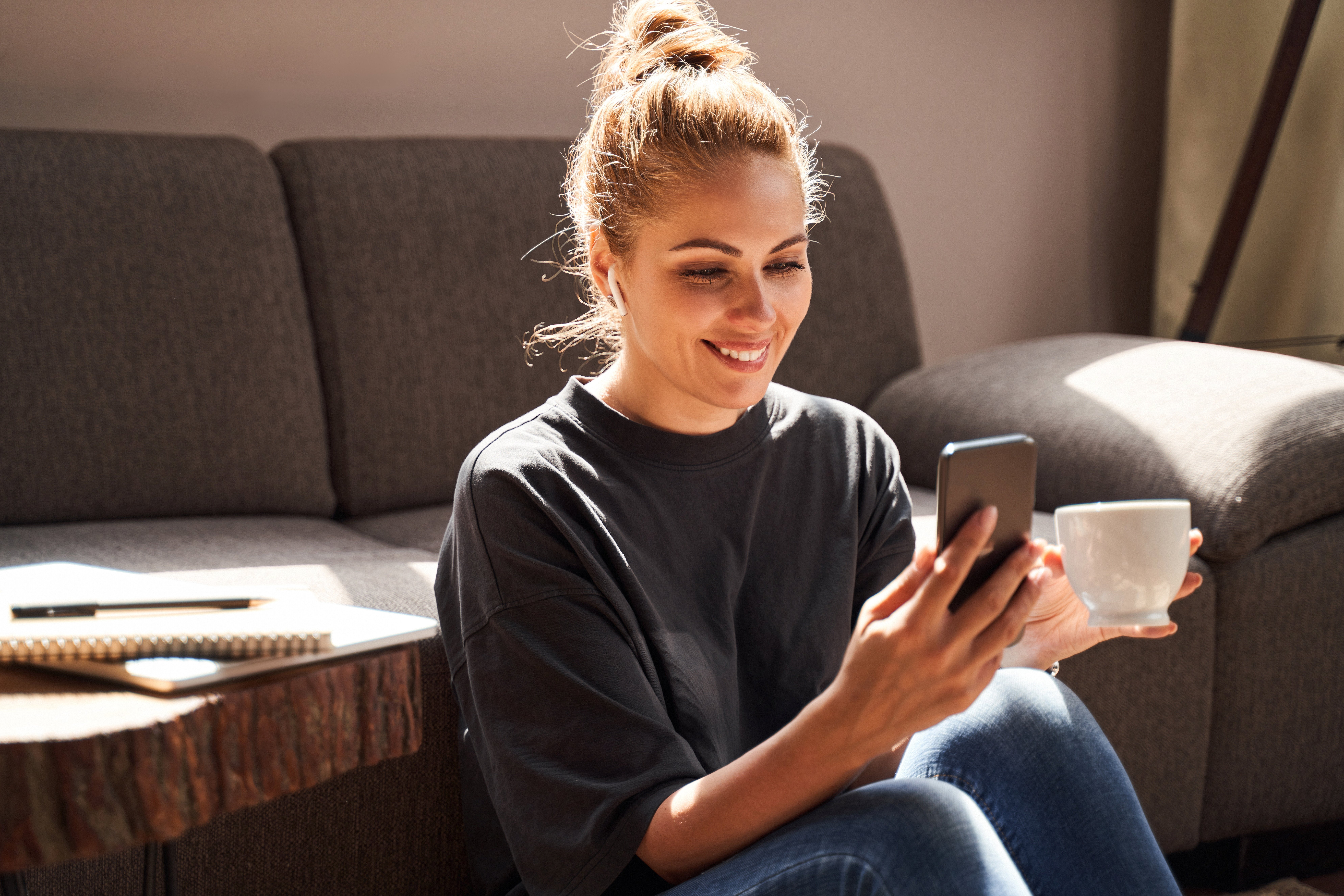  a lady sitting down with her phone and mug in hand speaking with a doctor