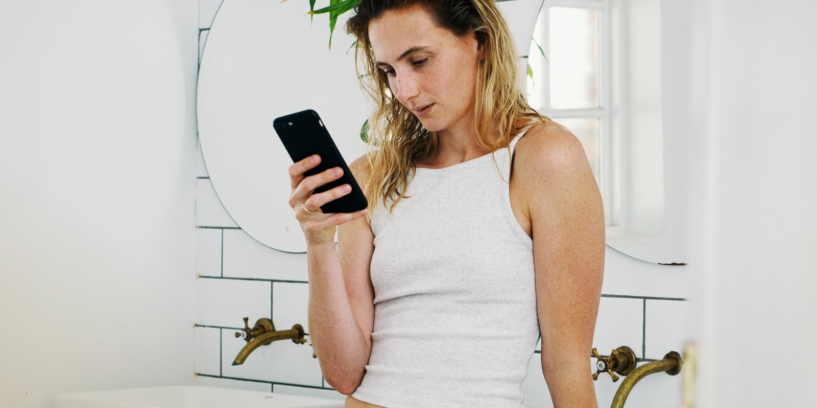 A white woman reading about morning after pill on her phone